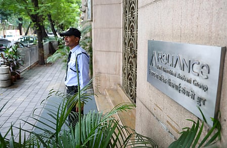 In the image Reliance office is shown and outside it a security guard is standing