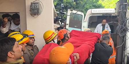 In the image Police is shown helping Fire Brigade to take the body of victims inside a ambulance