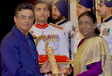 Image of actor R. Madhavan receiving Padma Shri award from President Droudpadi Murmu. the image is set in a formal official background. 