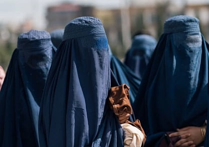 Group of women wearing blue burqas standing outdoors in Afghanistan, capturing cultural attire.
