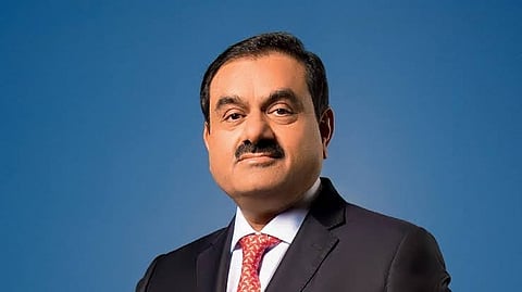 Gautam Adani looking at the camera with a suit and red tie.