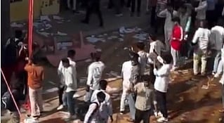 A crowded scene at a building with people climbing stairs and gathering outside. The environment appears busy and chaotic, suggesting a public event or crisis.
