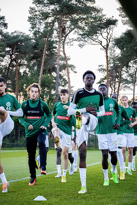 Image shows Football Players warming up for match.