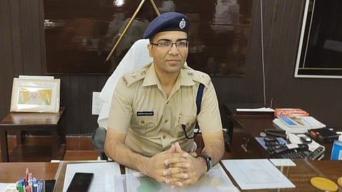IPS Deepak Gahlawat sitting at his desk, wearing his police uniform along with the cap.