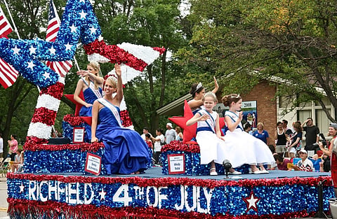 4th of July image from 2010
Richfield, Minnesota, USA. in the image people are celebrating American independence by dressing in theme of the American flag. women and children are seated on top of a vehicle decorated in blue white and red theme. 
