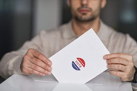 Image shows a paper mentioning vote placed in a box.