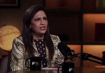 Image of ANI editor Smita Prakash in a podcast with Runjhun Sharma. She is seated in front of a podcast mic and is seated in a lit room.