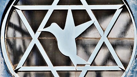 Decorative window grille with Star of David pattern and a bird silhouette in the center, conveying themes of peace and spirituality.