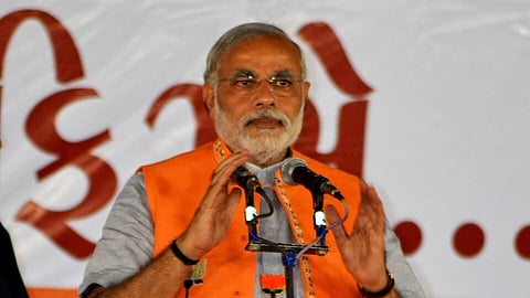 PM Narendra Modi in front of the mic ready to give a scripted speech.