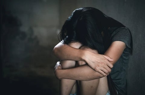 image shows a girl in a dark room.