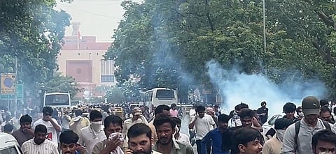 Image from the CJP delhi protest where a huge crowd is running while the tear gas thrown by the police and its smoke can be seen. 