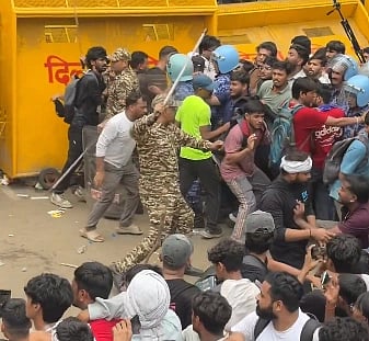 Image of police using lathis to disperse the crowd at jantar mantar delhi. 