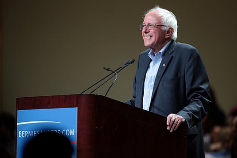 The image is of U.S. Senator Bernie Sanders addressing through mic.