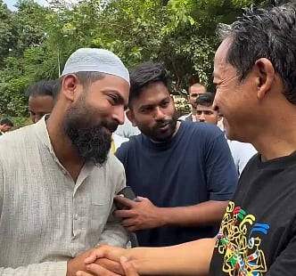 Image of Junaid Malik CJP food volunteer standing and shaking hands with Sonam Wangchuk. In the image Abhijeet Dipke is praising him  as well.