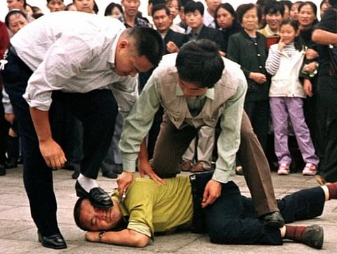 An old image from 2000, showing a Falun Gong demonstrator being apprehended by the police at Tiananmen Square. At least 300 people were arrested during the protest against the ban on Falun Gong on that day.