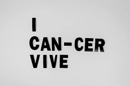 Creative message symbolizing cancer survival with black letters on white background.