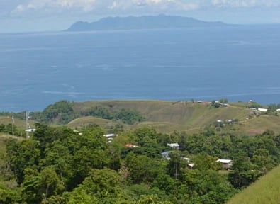 Discover the serene beauty of the lush green landscapes meeting the azure sea in the Solomon Islands.
