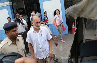 In the image Tarun Tejpal is shown under police custody
