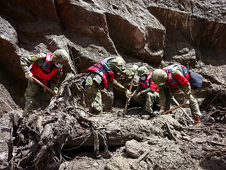 Rescue workers standing on mudslide after the nepal flash floods