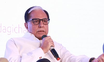 Image of Essel Group founder Subhash Chandra holding a mic and speaking in front of an audience