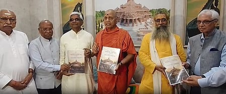 Image of six people standing and holding Ram Mandir covered booklet