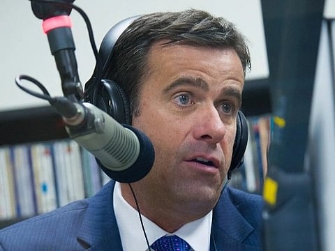 Image of John Ratcliffe at KETR at Texas A&M University–Commerce. in the image he is at a podcast and is wearing headphones/