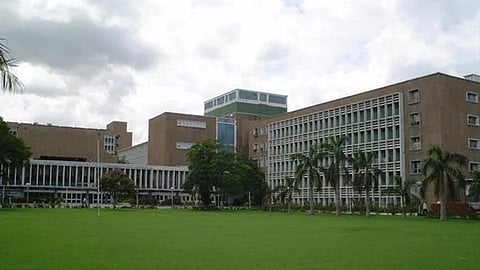 A brown building with a lawn in front.