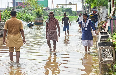 Image of people walking in road filled with mud water