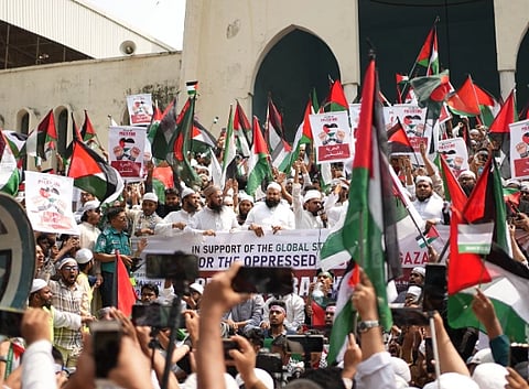 Large Pro-Palestinian demonstration in Dhaka with flags and banners supporting freedom and solidarity.
