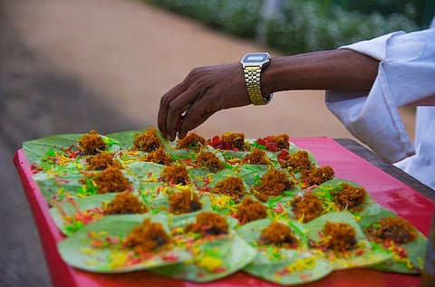 A street vendor prepares colorful paan on a tray, showcasing traditional Indian snack preparation.
