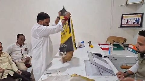In the image Yuva Sena district chief Vikram Randhave is shown taking dogs out of sack in the office of Panchayat Chief Dheeraj Bhamre