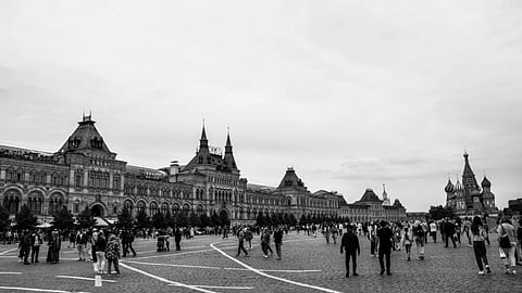 A black and white photo of Moscow's iconic Red Square with GUM and Saint Basil's Cathedral.
