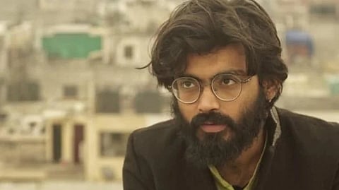 A man wearing specs, looking at the camera.