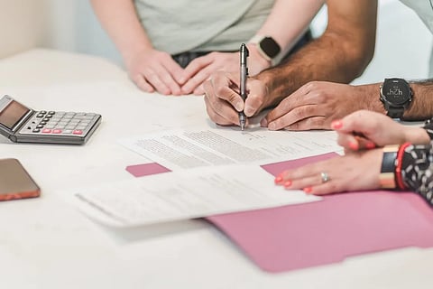 Elderly parents with adult child reviewing health insurance documents