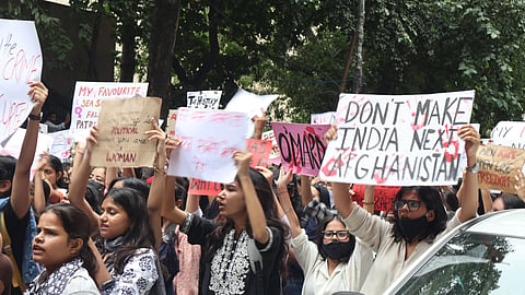 Image of female protestors raising placards and posters during the Miranda house protest over women's safety  in Delhi. 