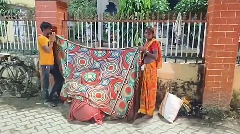 In the image the Bhadohi woman gives birth outside hospital while her family helps her