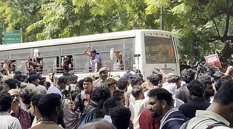 In the image protesters are shown being detained by police 