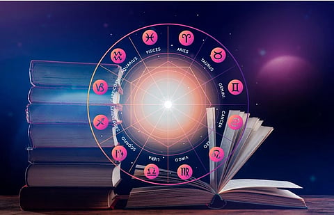A glowing zodiac wheel with labeled astrological signs floats above stacked books and an open book, creating a mystical, celestial atmosphere.