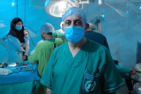 Experienced surgeon in operating room with medical team during surgery.