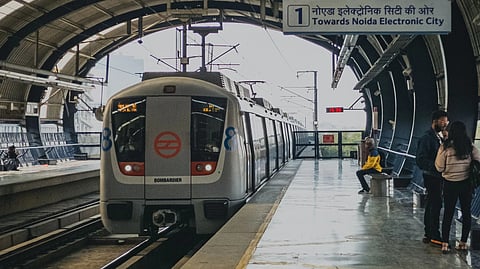 Passengers await the arrival of a train at a metro station in Delhi, India.