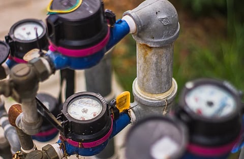 Detailed image of industrial water pressure gauges and pipes in an outdoor setting.
