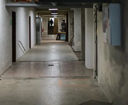 A dimly lit basement corridor with visible piping and industrial elements in Bratislava.
