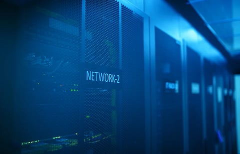 A modern server room featuring network equipment with blue illumination. Ideal for technology themes.
