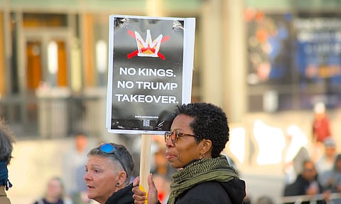 A peaceful protester in Towson holding a sign against political takeover.
