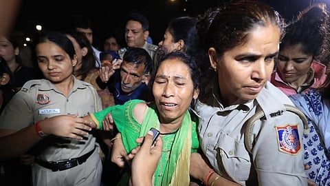 Police officials carrying a woman