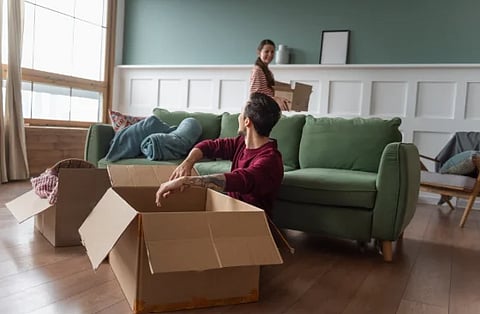 Image of young couple unboxing things in their living room. 