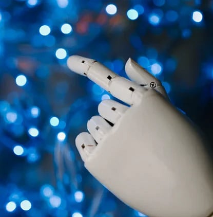 Close-up of a robotic hand with glowing blue bokeh background, symbolizing advanced technology.
