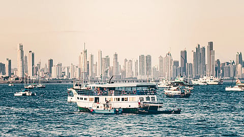 Captivating view of Panama City's skyline with boats sailing in the ocean under a clear sky.