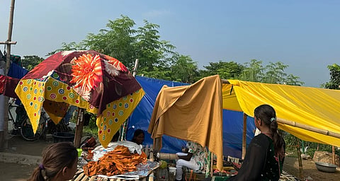 A flood-affected family going about their daily life inside a temporary tent
