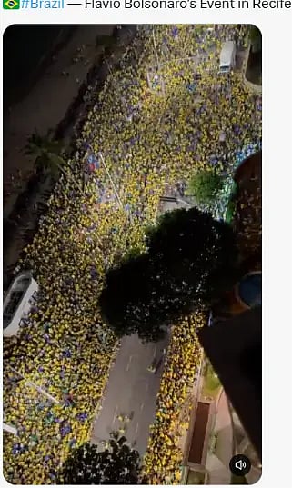 Night view from above of a street packed with people in yellow and supporters of Flávio Bolsonaro.